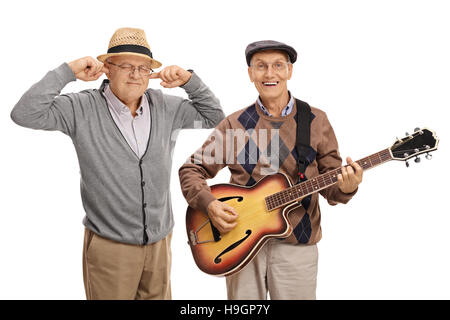 Homme mûr jouant de la guitare avec un autre homme boucher ses oreilles avec ses doigts isolé sur fond blanc Banque D'Images