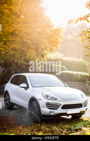 UK European Porsche Cayenne dans l'argent dans un parking dans le soleil d'automne. Banque D'Images