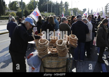 Athènes, Grèce. 24 novembre 2016. Un vendeur vend koulouri de son décrochage mobile pendant la manifestation. Des milliers de Grecs ont suivi l'appel du Syndicat de l'ADEDY (Confédération des fonctionnaires) et le Parti communiste de Grèce (KKE) commerce des filiales à l'Union européenne le PAME (Front militant de All-Workers) et avant de lutte des étudiants (MAS) pour une grève de 24 heures des fonctionnaires en Grèce et une marche de protestation au Parlement grec à Athènes. Ils ont protesté contre la politique du gouvernement de plus de coupes et la réduction des droits des travailleurs. Crédit : Michael Debets/Alamy Live News Banque D'Images