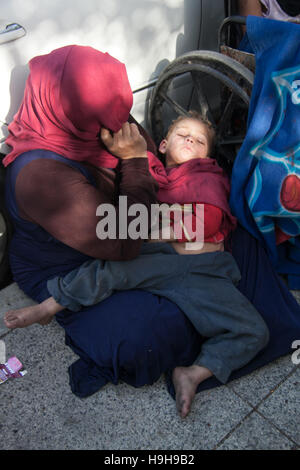 Beyrouth Liban. 24 novembre 2016. Un jeune enfant réfugié d'Alep est craddled dans les bras de sa mère s'échappe de la Syrie déchirée par la guerre de la rue et la mendicité dans les rues de la capitale libanaise. Le Liban est désormais plus de 1 millions de réfugiés depuis le début de la guerre civile en Syrie voisine Crédit : amer ghazzal/Alamy Live News Banque D'Images