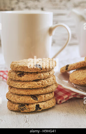 Pile de biscuits complet avec des raisins sur table rustique blanc Banque D'Images