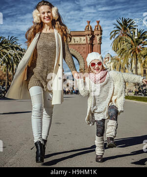 À Barcelone pour un hiver parfait. Portrait of happy trendy mère et fille près de Arc de Triomf de Barcelone, Espagne randonnée pédestre Banque D'Images