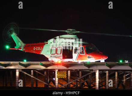 HM Hélicoptère de recherche et sauvetage de la Garde côtière 104 atterrit sur un héliport au St Mary's Hospital sur l'île de Wight dans la nuit Banque D'Images