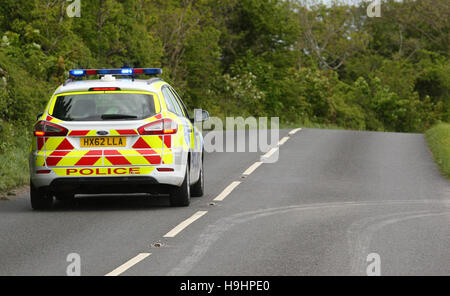 A Hampshire Constabulary voiture de police répond sur un pays rural route sur feux bleus Banque D'Images