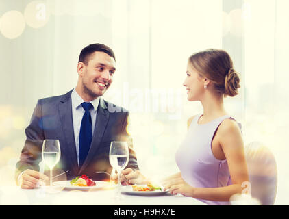 Smiling couple eating plat principal au restaurant Banque D'Images