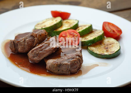 Médaillon de la viande arrosée de sauce et courgette Banque D'Images