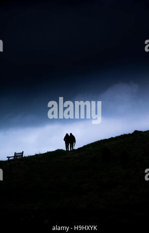 Deux personnes vu en silhouette comme ils marchent sur plage de Towan à Newquay, Cornwall. Banque D'Images