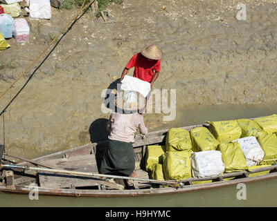 Marchandises devant être chargés sur un petit bateau pour la distribution locale le long des affluents de la rivière Kaladan au Myanmar. Banque D'Images