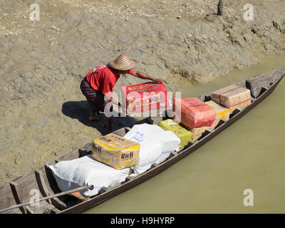 Marchandises devant être chargés sur un petit bateau pour la distribution locale le long des affluents de la rivière Kaladan au Myanmar. Banque D'Images