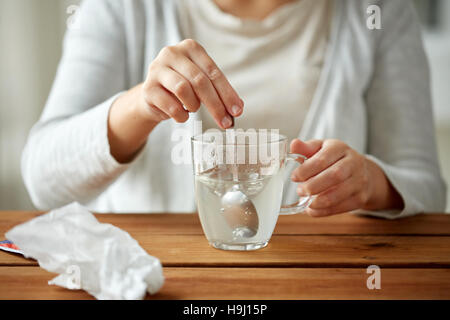 Femme en remuant de médicament en tasse avec cuillère Banque D'Images