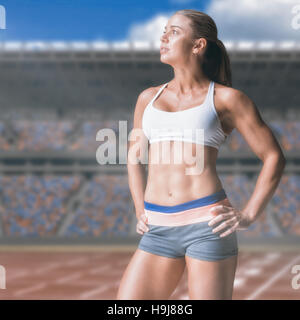 Image composite de l'athlète féminin posant avec mains sur la hanche Banque D'Images