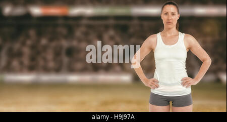 Image composite de portrait de femme athlète standing with hands on hips Banque D'Images
