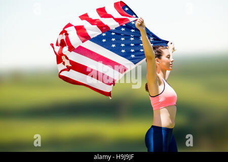 Image composite de vue de profil de l'athlète qui soulève un drapeau américain Banque D'Images