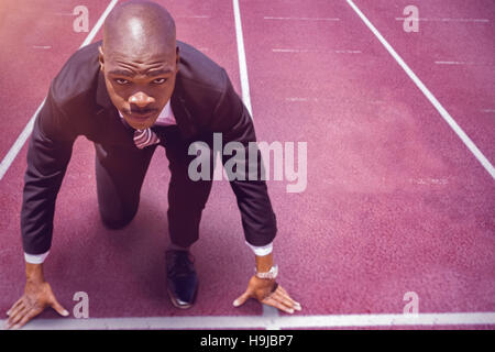 Composite image of businessman in starting blocks Banque D'Images