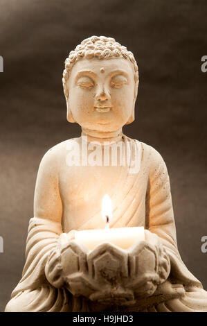 Gros plan de Bouddha tenant une bougie Banque D'Images