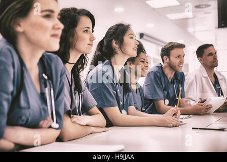 Les étudiants en médecine à l'écoute sitting at desk Banque D'Images