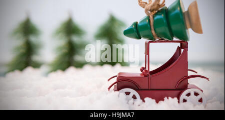 Toy voiture transportant arbre de Noël sur neige artificielle Banque D'Images