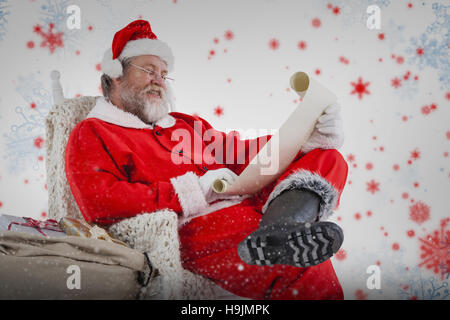 Image composite de santa claus reading liste de souhaits sur faites défiler jusqu'à l'arrière-plan blanc Banque D'Images