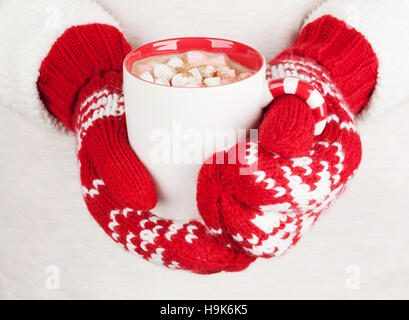 Les mains tenant du chocolat chaud avec de la guimauve Banque D'Images