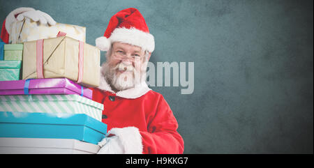 Composite image of santa claus holding christmas presents Banque D'Images