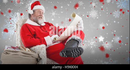 Image composite de santa claus reading liste de souhaits sur faites défiler jusqu'à l'arrière-plan blanc Banque D'Images