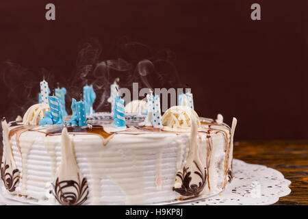 Délicieux gâteau d'anniversaire fait maison avec beaucoup de bougies éteintes, serviette blanche sur le bureau en bois Banque D'Images