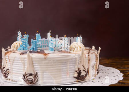 Blanc tarte d'anniversaire fait maison avec beaucoup de bougies éteintes, serviette blanche sur le bureau en bois Banque D'Images