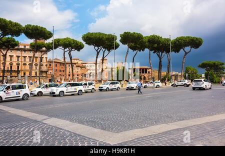 Le Taxi file en attendant les clients le long d'une route principale très fréquentée à Rome, Italie. Banque D'Images