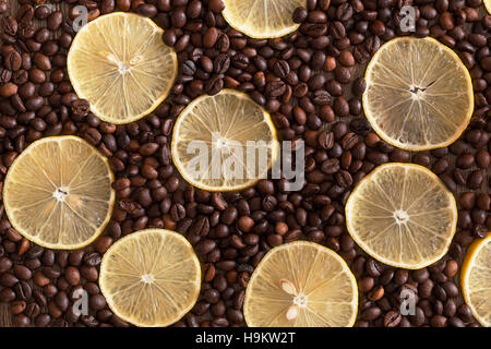 Les tranches de citron se trouvant entre le grain de café sur une table en bois. Banque D'Images