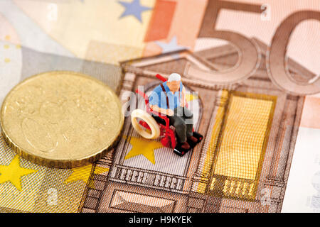 Figurine d'un homme en fauteuil roulant sur un projet de loi euro Banque D'Images