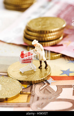 Figurine d'une femme poussant un chariot sur d'euros Banque D'Images