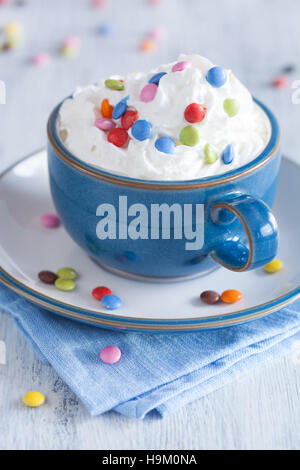 Café avec la crème fouettée et des pastilles de chocolat colorés Banque D'Images