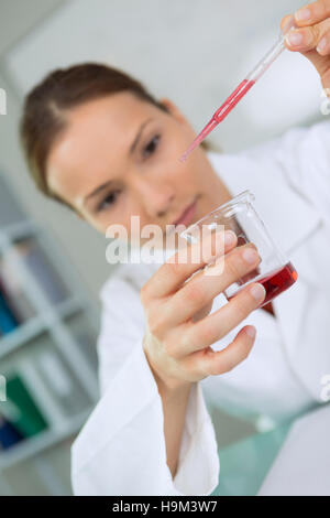 Femme travaillant avec des tubes de sang dans un laboratoire Banque D'Images