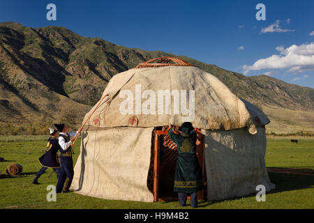 Les hommes en costume traditionnel monter feutre de laine couvre plus de cadre de toit de yourte en retournerais sans hésiter au Kazakhstan Banque D'Images