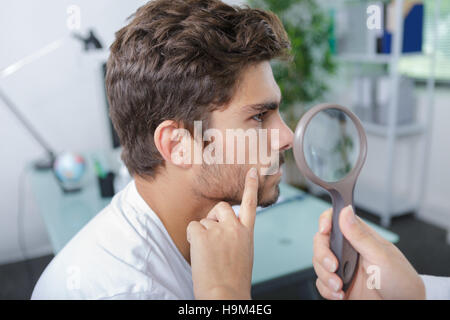 Close-up of doctors hands contrôle mans moles Banque D'Images
