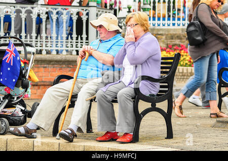 Vieux couple assis sur un banc dans le parc John F Kennedy, de la promenade, Cobh, dans le comté de Cork, Irlande. Banque D'Images