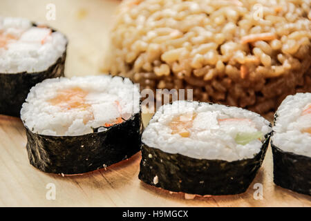 Phtograph de certaines tranches Sushi roll riz frit et sur une table en bois Banque D'Images