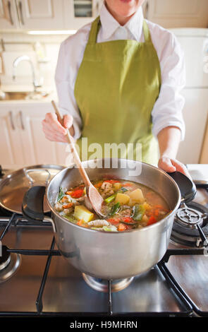 Soupe aux légumes cuisine femme dans le pot Banque D'Images