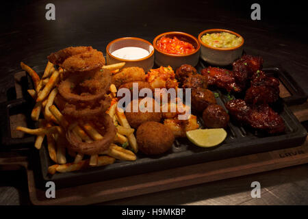 Lanières de poulet frit, ailes de poulet, d'oignon, des bâtonnets de poisson et frites, partage de Pune, Inde Banque D'Images