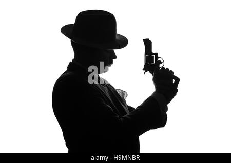 Silhouette de détective privé avec un pistolet dans la main droite. Séjour de l'agent d'un côté à l'appareil photo et se présente comme mafieux Al Capone. Scène criminelle. Studio shot Banque D'Images