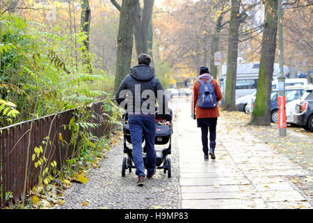 Famille marchant père papa poussant des bébés jumeaux dans une poussette de bébé dans une rue en automne Prenzlauer Berg quartier Berlin, Allemagne, Europe, eu KATHY DEWITT Banque D'Images