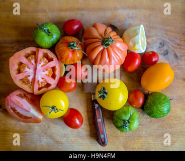 Diverses variétés de tomates sur la planche à hacher au couteau Banque D'Images