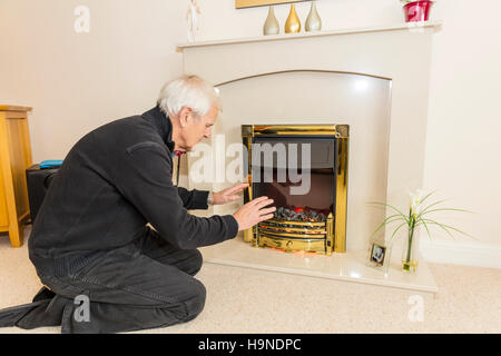 Dao en essayant de garder au chaud les mains de réchauffement près d'un feu en gardant les factures n'ont pas les moyens de chauffage des factures d'énergie gaz UK Angleterre Banque D'Images