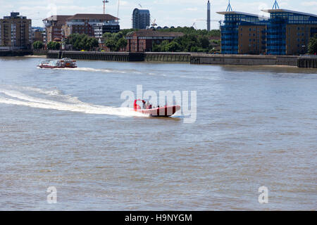 Un ferry et de vedettes qui se déplacent le long de la rivière Thames près de Canary Wharf Pier, Londres. 14 juillet 2014. Banque D'Images