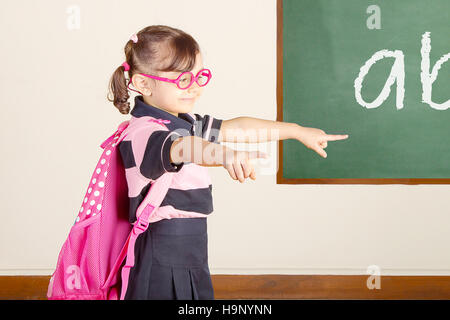 Peu Smart School Girl Pointing aux élèves de l'école Banque D'Images