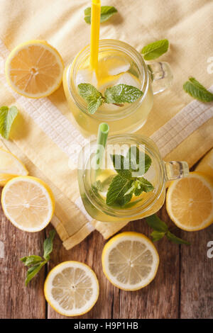 Limonade rafraîchissante avec des cubes de glace et de menthe close up dans un bocal en verre sur la table. vertical Vue de dessus Banque D'Images