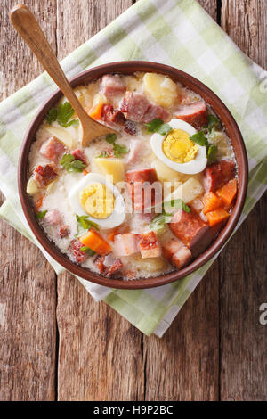 La cuisine polonaise : Zurek soupe avec de la viande fumée close up sur la table. Vue verticale d'en haut Banque D'Images