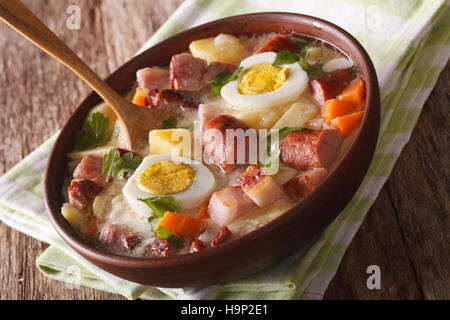 La cuisine polonaise : Zurek soupe avec de la viande fumée à proximité, sur la table. Banque D'Images