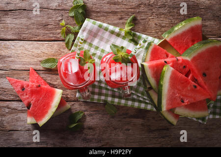 Cocktail pastèque rafraîchissante avec de la glace et la menthe close up dans un bocal en verre sur la table horizontale vue du dessus. Banque D'Images
