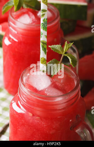 Le jus de melon d'eau fraîche avec de la glace à la menthe et macro dans des pots de verre vertical. Banque D'Images